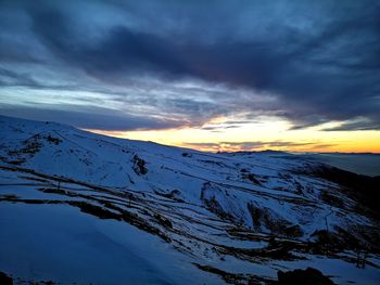 Scenic view of snowcapped mountains against sky during sunset