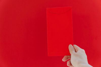 Close-up of human hand against red background