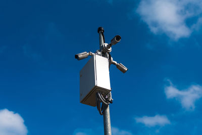 Low angle view of telephone pole against blue sky