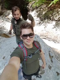 High angle view of male hikers standing on rock formation in forest