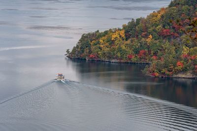 High angle view of boat cruising in lake