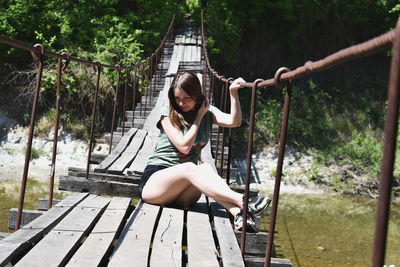 Portrait of woman sitting on rope in playground