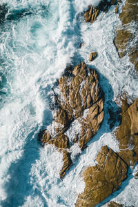 Aerial image of waves hitting the coastline of the french island corse near the village lumio.