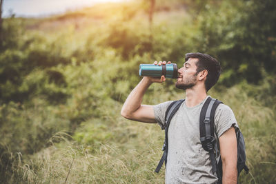 Young man photographing camera on field