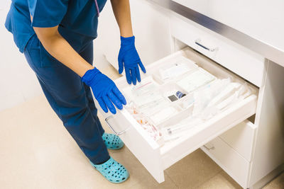 Nurse taking inventory and restocking medical supplies at hospital