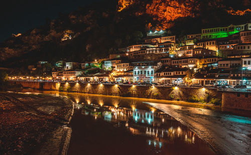 Illuminated bridge over river at night