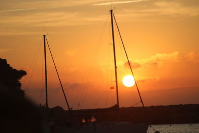 Sailboats in sea against sky during sunset