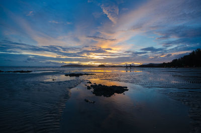 Scenic view of beach against sky during sunset