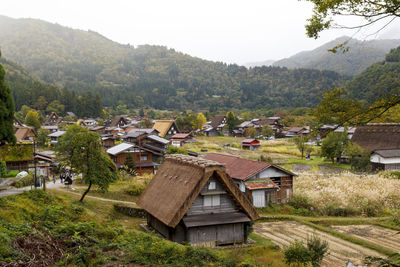 Scenic view of village by houses against sky