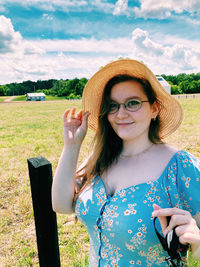 Portrait of young woman standing on field