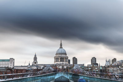 Buildings in city against cloudy sky