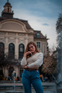 Portrait of woman standing against built structure
