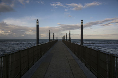 Pier over sea against sky during sunset