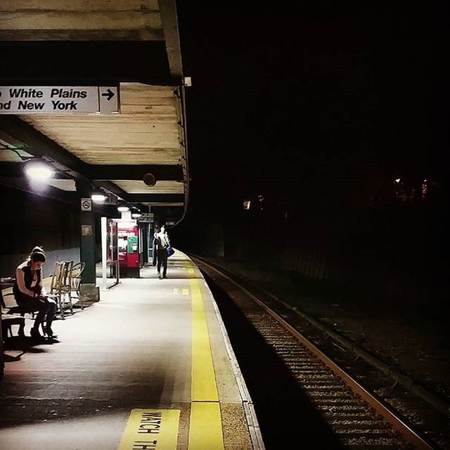 transportation, railroad track, railroad station platform, railroad station, public transportation, illuminated, rail transportation, the way forward, mode of transport, men, travel, diminishing perspective, indoors, incidental people, city life, built structure, architecture, night, train - vehicle
