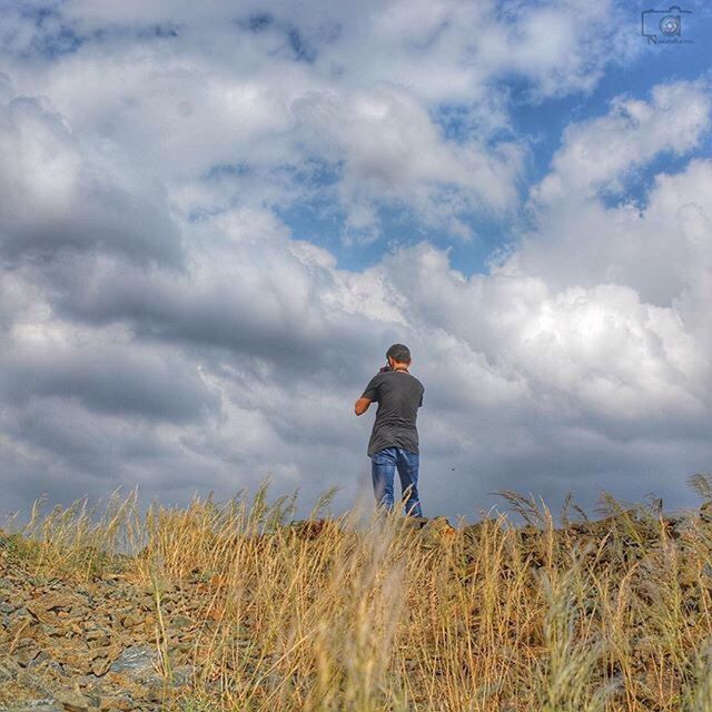 SILHOUETTE OF WOMAN STANDING ON LANDSCAPE AGAINST CLOUDY SKY