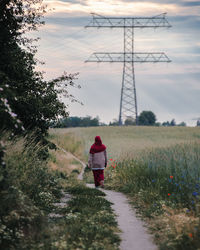 Rear view of woman walking on field