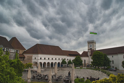 Buildings in city against cloudy sky