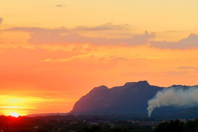Scenic view of silhouette mountains against romantic sky at sunset