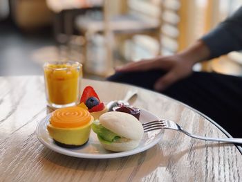 Midsection of person with drink on table