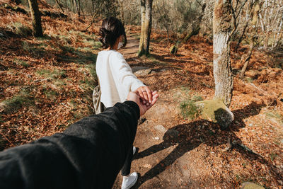 Rear view of woman hands in forest