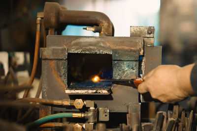 Cropped hand of worker holding lighting equipment in factory