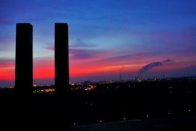 Silhouette buildings against sky during sunset