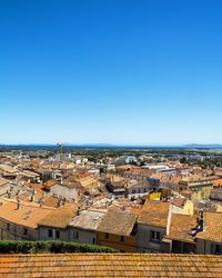 High angle view of cityscape against clear blue sky