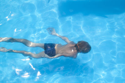 High angle view of boy swimming in pool