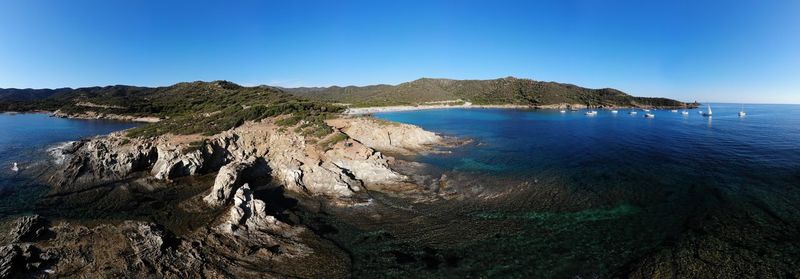 Scenic view of bay against clear blue sky