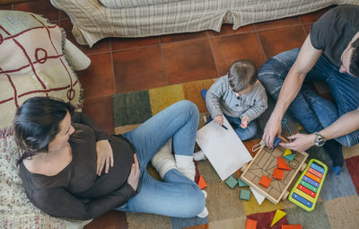 High angle view parents and son playing with toys at home