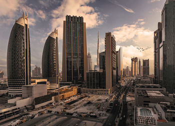 Skyscrapers in city against sky during sunset