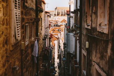 High angle view of narrow alley amidst buildings in city