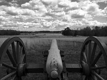 View of field against cloudy sky