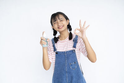 Portrait of smiling woman standing against white background