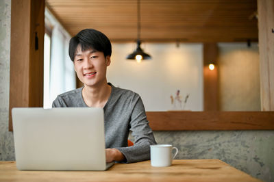 Young woman using laptop at home