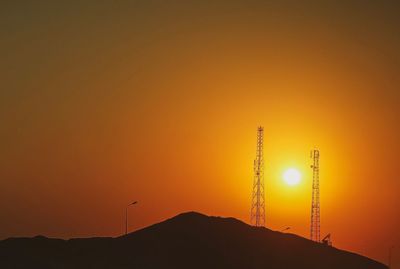 Silhouette mountain against orange sky