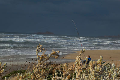 Fishing net on beach against sky