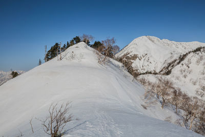 Scenic view of snowcapped mountains against clear blue sky