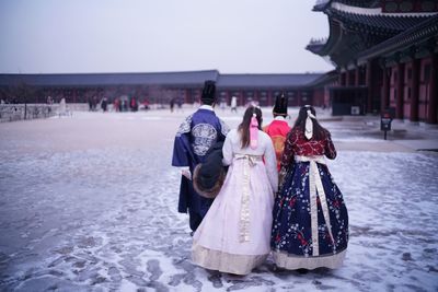 People in snow against clear sky