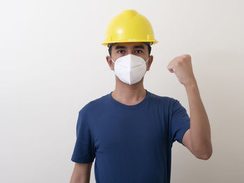 Portrait of young man standing against white background