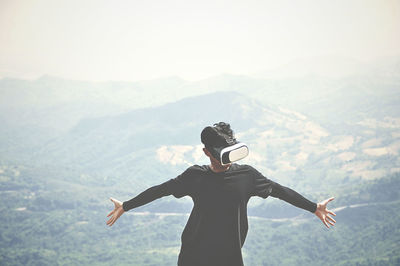 Man wearing virtual reality simulator on mountain