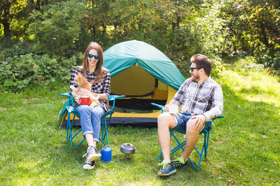 Young couple sitting on tent