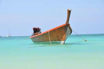 Abandoned boat on calm blue sea against clear sky