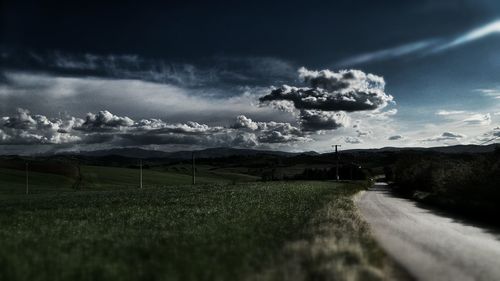 Scenic view of field against cloudy sky