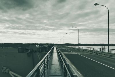 Railroad tracks against cloudy sky