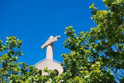 Low angle view of statue against clear blue sky