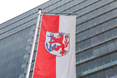 Low angle view of flag against building in city