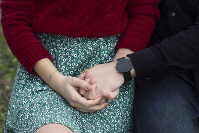 Midsection of couple holding hands