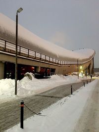 Snow covered street against sky