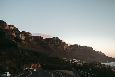 Road by mountains against sky